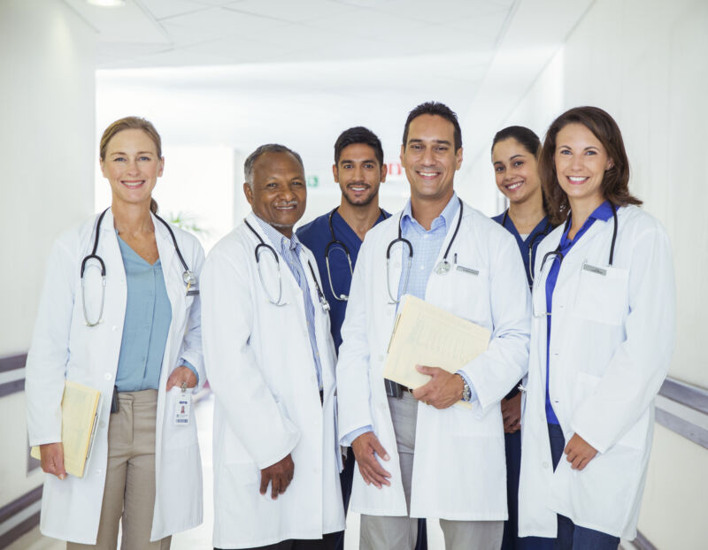 Image of a group of people wearing lab coats, scrubs, and carrying stethoscopes.