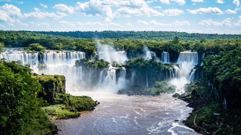 Image of a large waterfall embedded in a tropical forest.