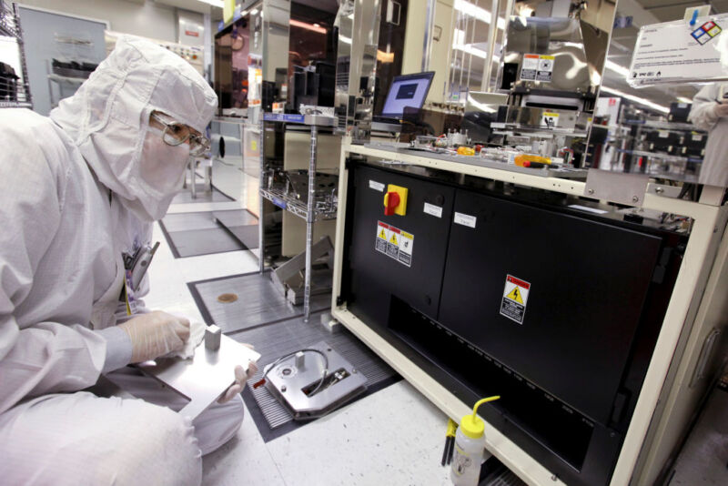 A worker prepares a silicon wafer machine in a clean room at the Texas Instruments semiconductor fabrication plant in Dallas, Texas.