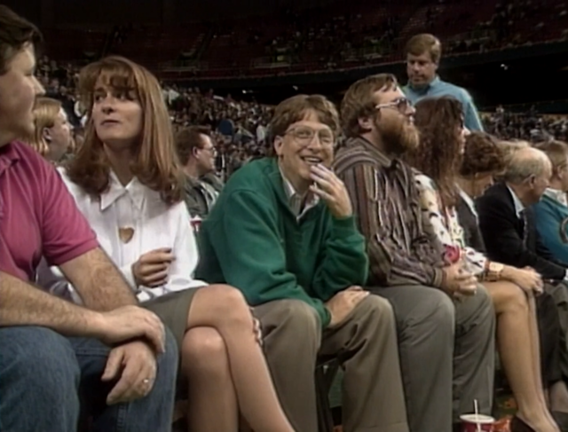 Former Microsoft CEO Bill Gates sits with then-fiance Melinda French at a basketball game, circa 1993.