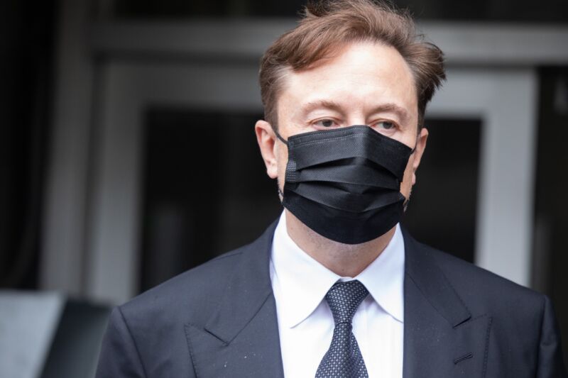 Elon Musk wearing a suit and mask as he leaves a federal courthouse.