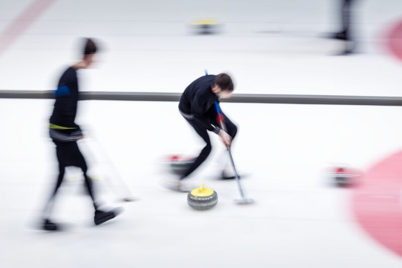 Two men curling in blurry motion photo