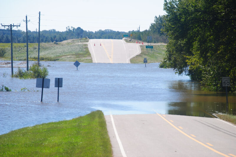 Image of a road with a low lying section under water.