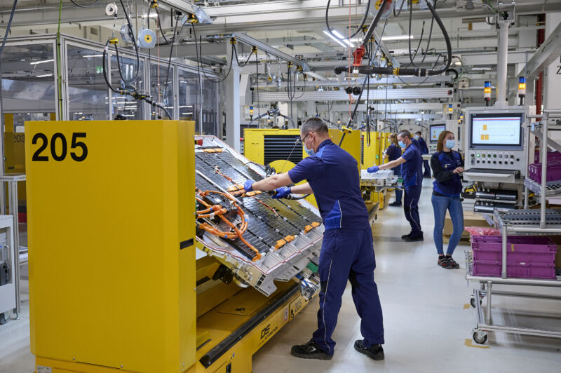 A man works on a BMW electric vehicle battery pack at the factory