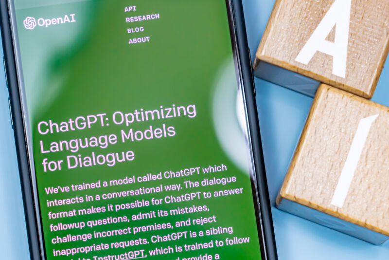 The ChatGPT website is displayed on a smartphone screen next to two blocks displaying the letters