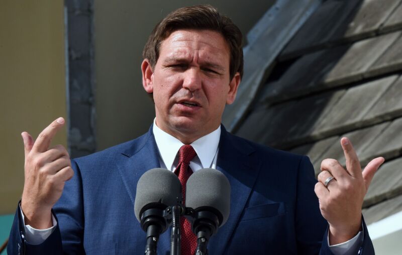 Florida Gov. Ron DeSantis speaks at a press conference while gesturing with his hands.