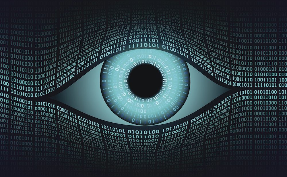 Un ojo compuesto por código binario (1 y 0) que simboliza la vigilancia digital. El ojo, en tonos azules y grises, está rodeado por una matriz de números que representa el monitoreo constante de datos y el seguimiento de la información personal en el mundo digital.