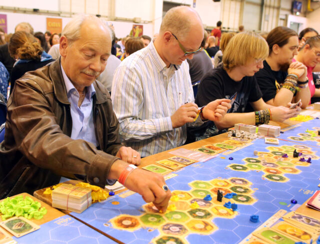 Klaus Teuber in 2015 at a games fair in Essen, Germany, attempting to set a world record with more than 1,000 others for the largest simultaneous game of <em>Catan.