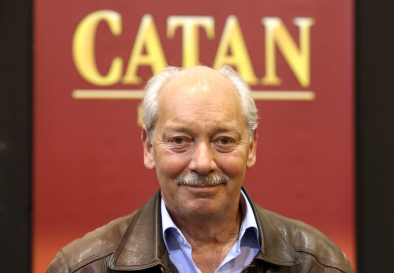 Klaus Teuber in front of a Catan type logo