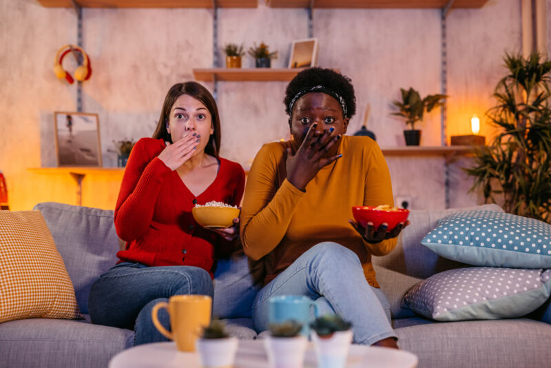 Two women watching TV at home