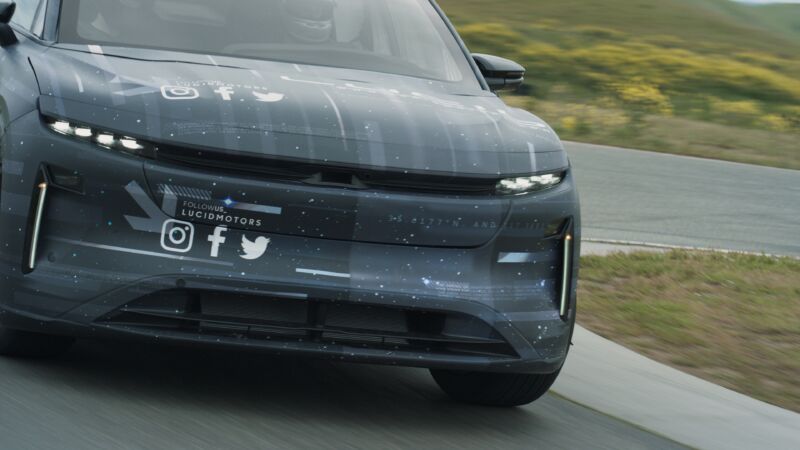 A Lucid Gravity SUV in a concealing wrap, testing on the road