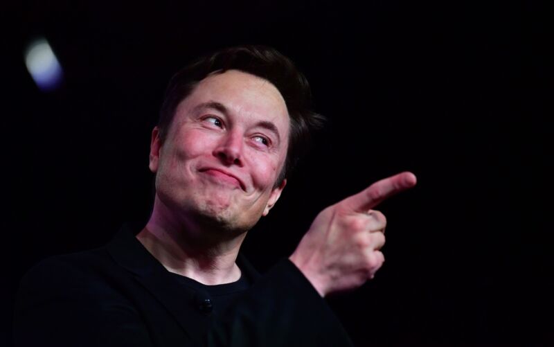 Tesla CEO Elon Musk smiling and pointing with his right index finger.