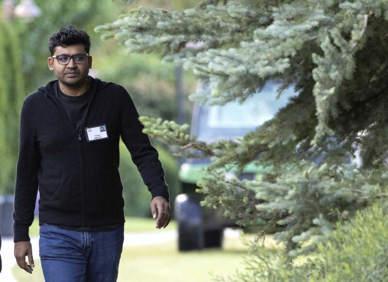 Former Twitter CEO Parag Agrawal walking outside while wearing a casual shirt and jeans.