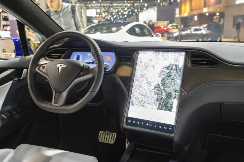 The interior of the Tesla Model X SUV. A map is displayed on the large touch panel next to the steering wheel.