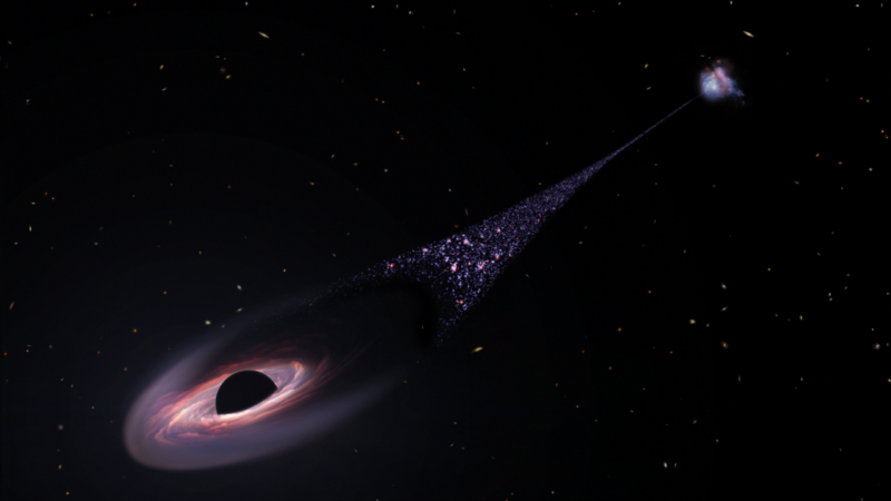 image of a colored disk on a dark background, with a trail of small bright objects behind it.