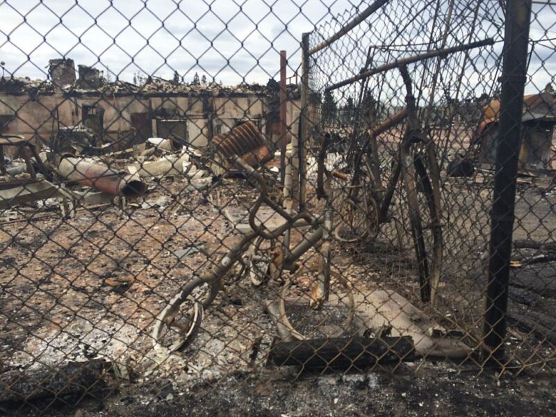 Images of charred bicycles in front of a damaged building.