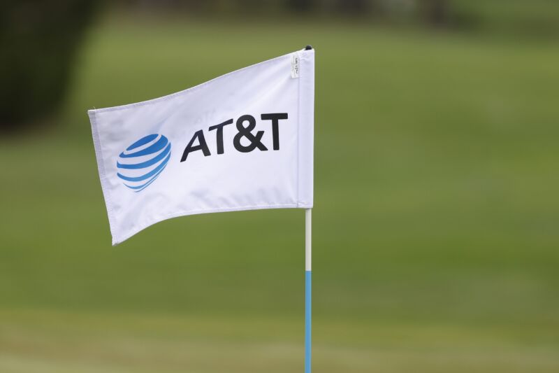 A flag with an AT&T logo on a golf course.