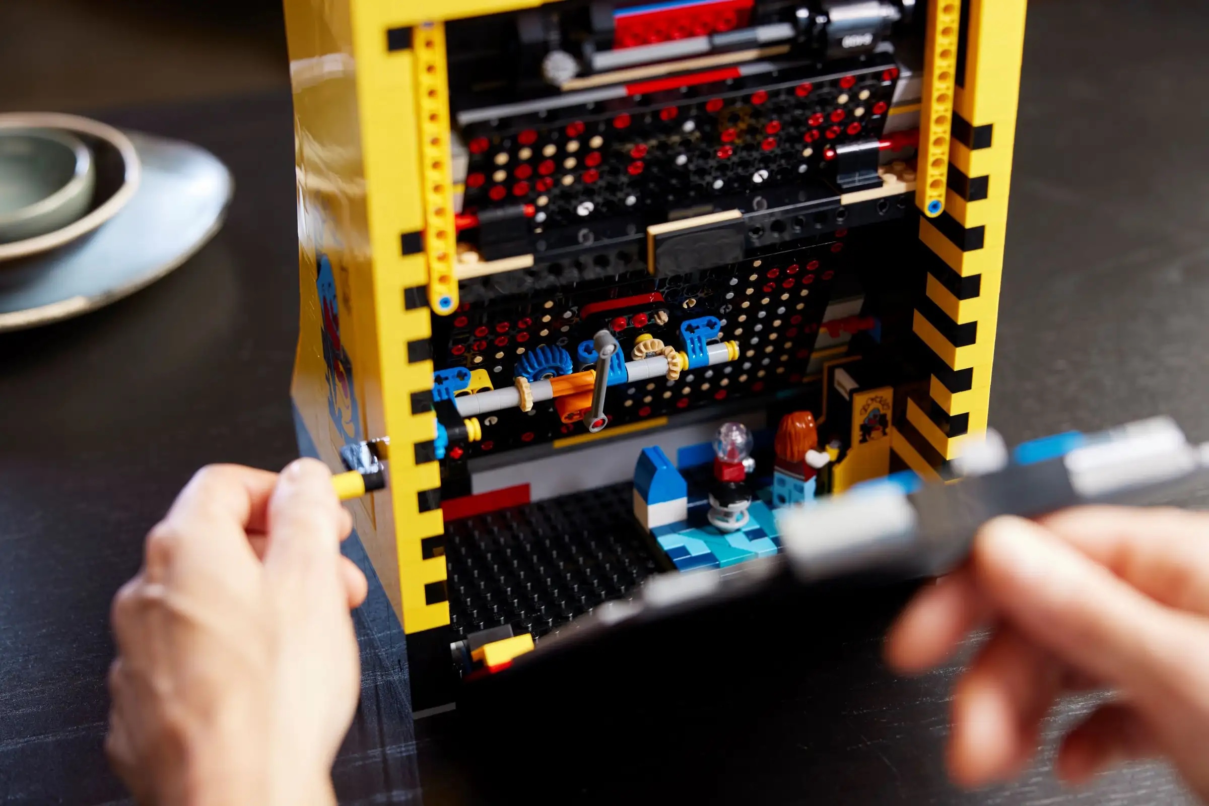 The back of the cabinet pulls off, revealing the set's lone minifig and a second, small-scale Pac-Man cabinet. Also note the set's clever use of gears to make the "screen" move.
