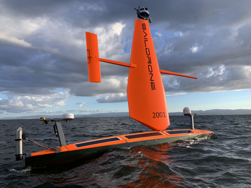 Image of a thin floating orange board with a solid upright wing and solar panels.