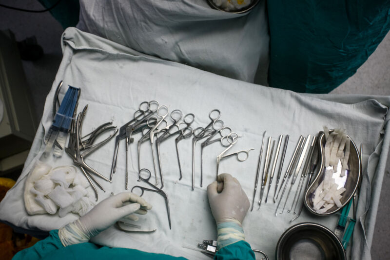 Surgical implements are seen on a tray during a surgery.