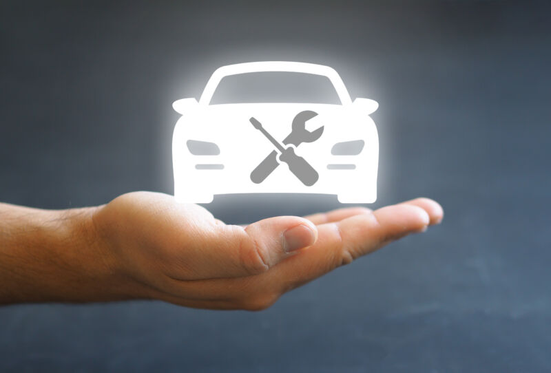 A glowing icon of a car with a crossed screwdriver and wrench floats above a human hand