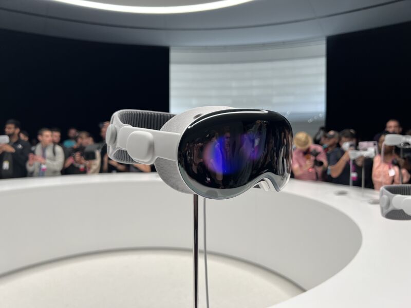 An AR headset sits on a stand in a public viewing area.
