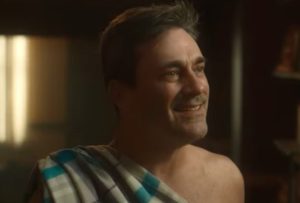 John Hamm as Gabriel draped in a checkered sheet, like a toga