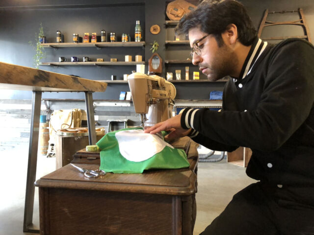 Roberto Hoyos sewing a pillow.