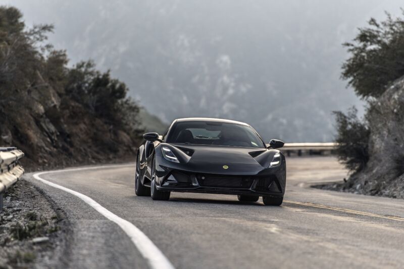 A person drives a Lotus Emira on a mountain road