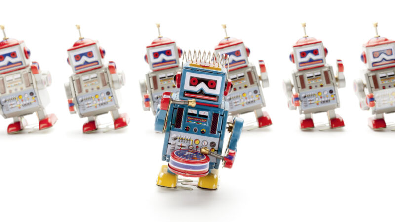 Tin robots dance in a stock photo.