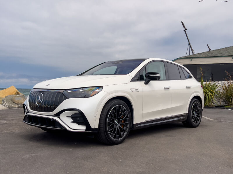 A white Mercedes AMG EQE SUV parked by the ocean