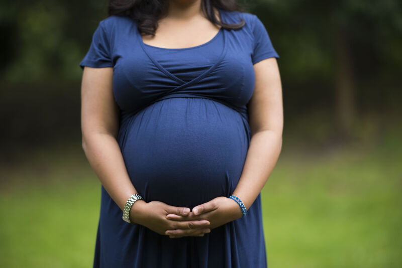 A pregnant woman holds her belly on September 27, 2016.