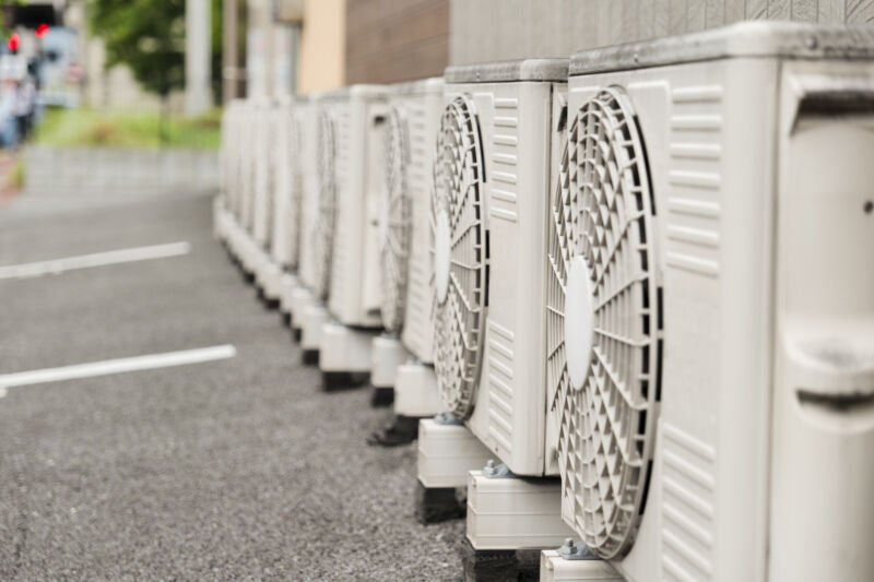 A row of grey metal boxes with embedded fans, used as air conditioners.