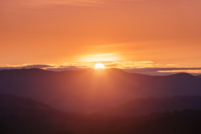 Image of an orange sunrise with some clouds.