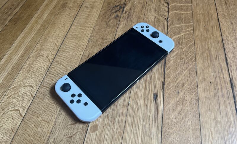 A Switch with white joycons on a wood surface