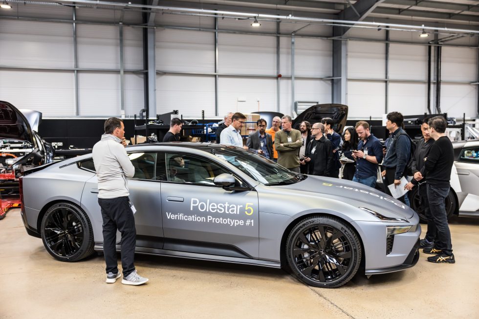 Pete Allen, trưởng phòng R&D Polestar Anh (áo xanh) đứng sau một mẫu Polestar 5 và nói chuyện với một số nhà báo đã tụ họp.