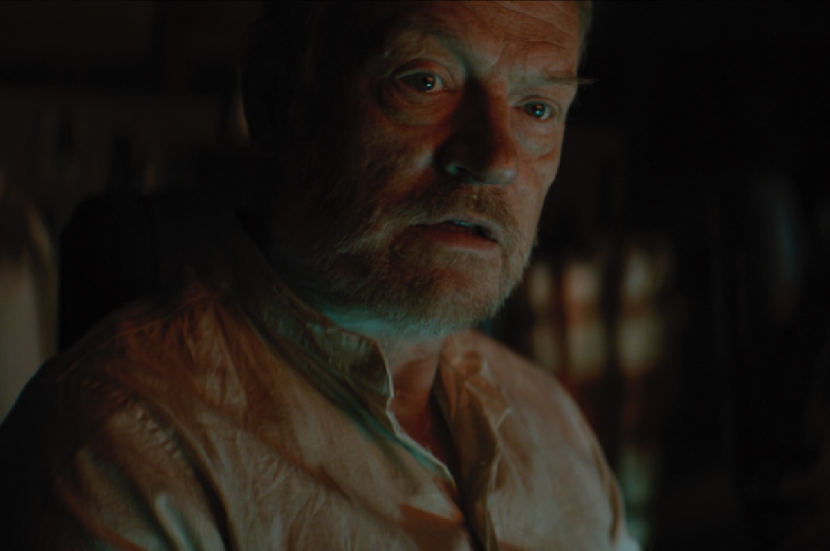 Close-up of aging man with white beard looking somber and a bit disheveled