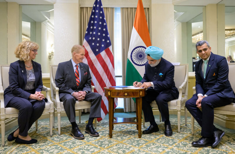 Taranjit Sandhu, India's ambassador to the United States, signs the Artemis Accords in Washington on June 21. NASA Administrator Bill Nelson looks on from across the table.