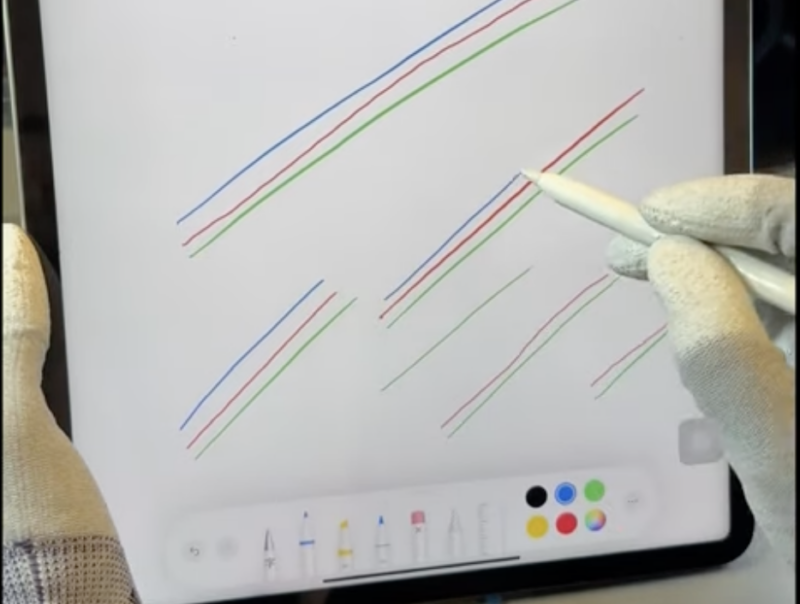 Gloved hands using an Apple Pencil on an iPad Pro with squiggly results