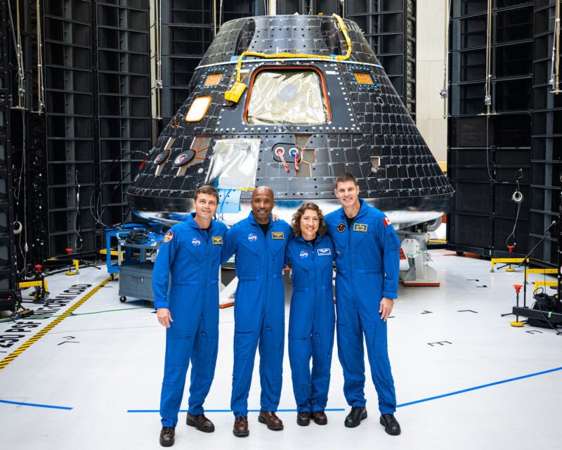 Artemis II commander Reid Wiseman, pilot Victor Glover, and mission specialists Christina Koch and Jeremy Hansen pose with their Orion spacecraft at NASA's Kennedy Space Center in Florida.