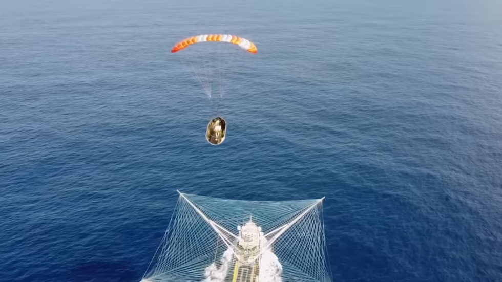 Video of a Falcon 9 fairing half falling into a large net on a recovery ship.