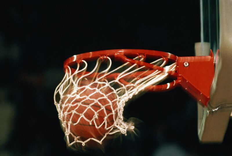 A basketball falling through the net of a basketball hoop
