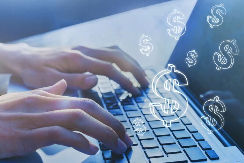 Dollar signs superimposed on a photo of a person's hands typing on a laptop keyboard.