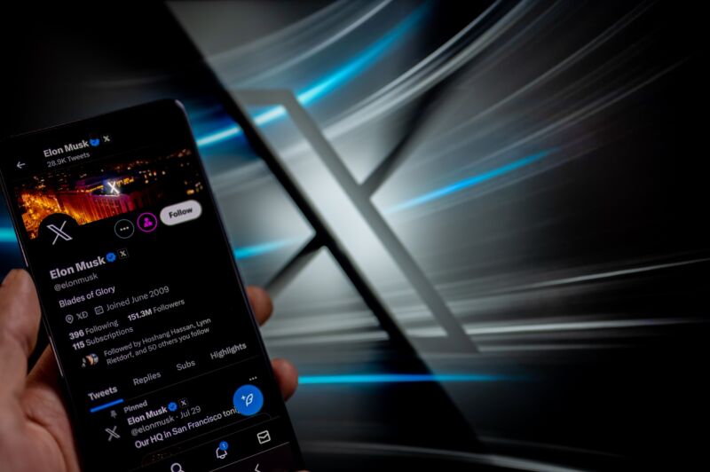 Elon Musk's X profile displayed on a smartphone in front of the new 
