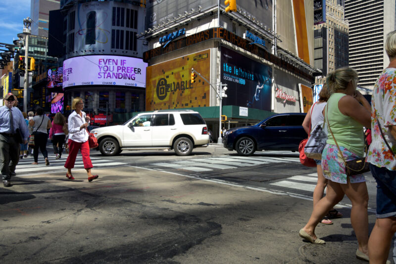 New York City, USA - September 16, 2015: A group of pedestrians crossing Broadway along 42nd Street, Midtown Manhattan.