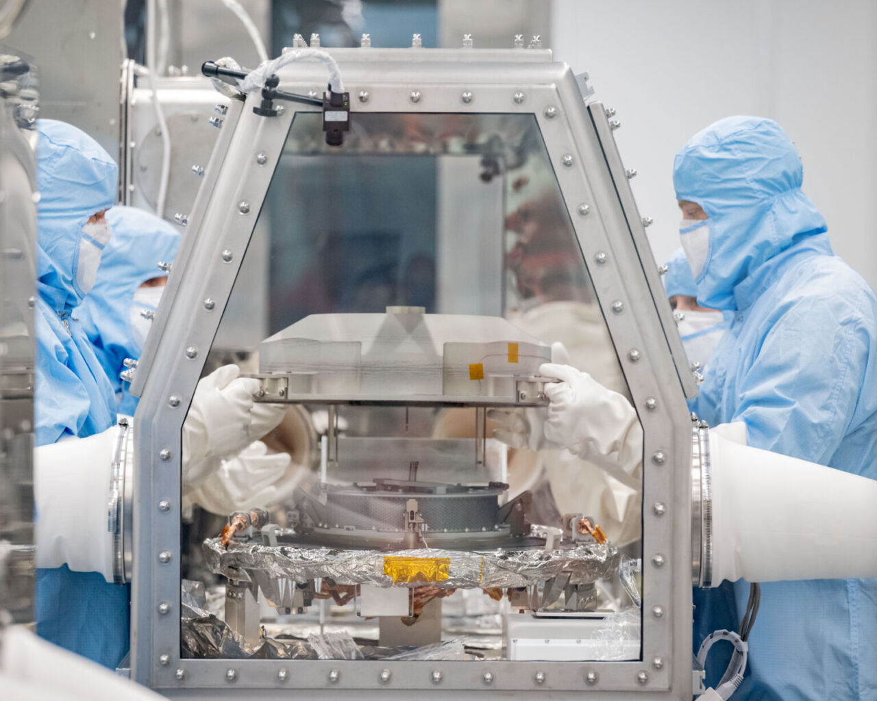 Los científicos quitan la tapa del contenedor de muestras OSIRIS-REx en el Centro Espacial Johnson de la NASA en Houston.