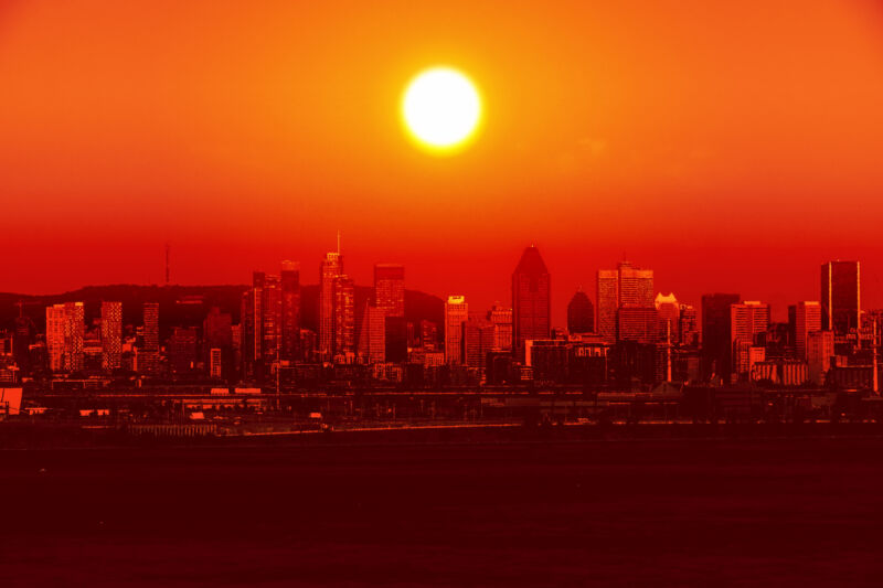 Image of a city skyline backlit by an orange sun.