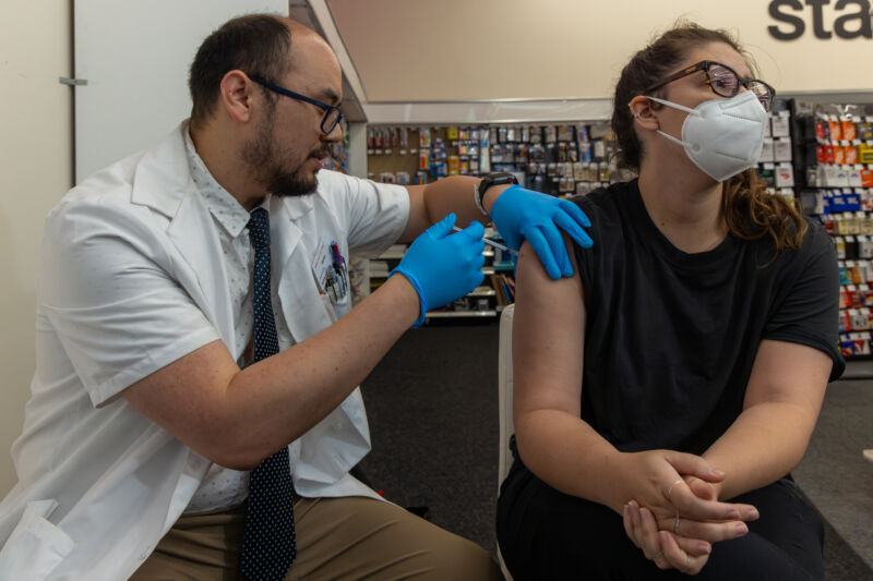 A pharmacist administers an updated COVID-19 vaccine at a CVS Pharmacy in Eagle Rock, California.