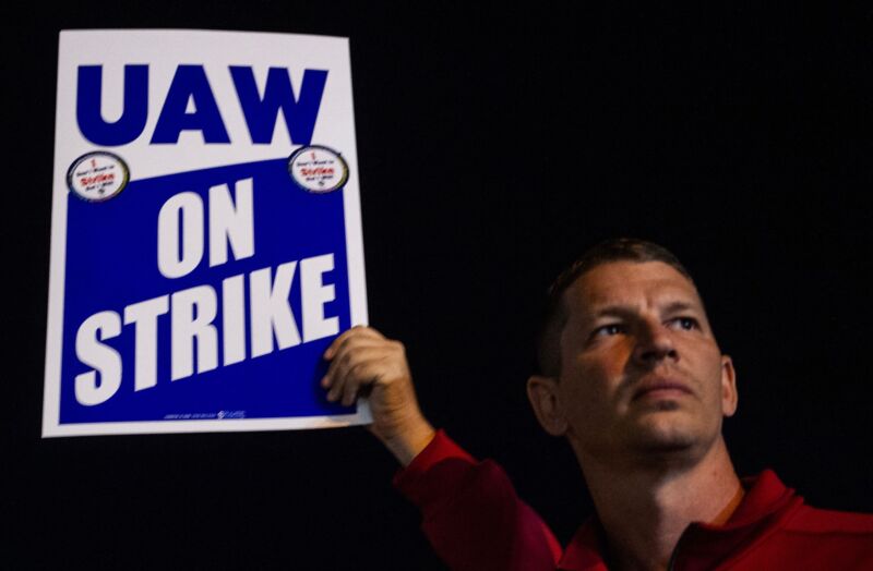 Members of the UAW (United Auto Workers) picket and hold signs outside of the UAW Local 900 headquarters across the street from the Ford Assembly Plant in Wayne, Michigan on September 15, 2023.