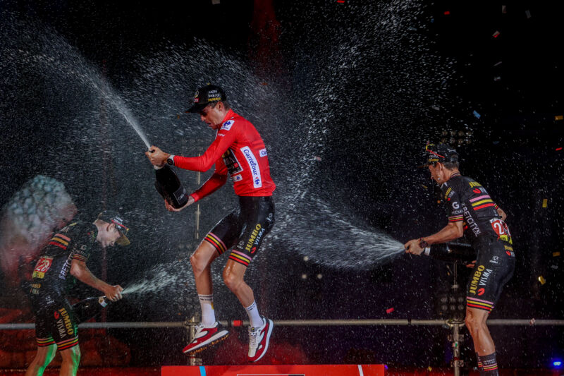 Cyclist Sepp Kuss, center, on the podium of the 21st stage of the Vuelta a España with Jonas Vingegaard, left, and Primož Roglič, right.